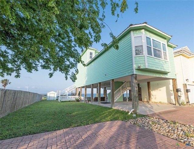 106 Clement Cv, Port Lavaca, TX 77979 - back of house with a yard, stairway, fence, a carport, and driveway
