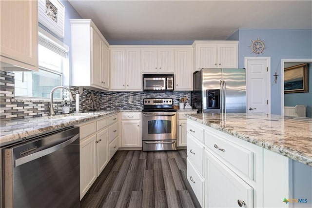 106 Clement Cv, Port Lavaca, TX 77979 - kitchen with a sink, light stone counters, stainless steel appliances, and dark wood finished floors