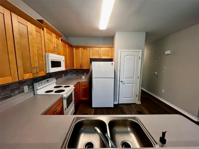 kitchen featuring a sink, white appliances, dark wood-type flooring, and decorative backsplash