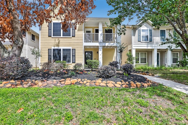 multi unit property featuring a front yard and a balcony