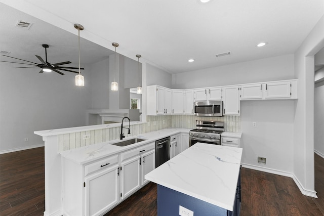 kitchen featuring visible vents, light stone countertops, appliances with stainless steel finishes, and a sink