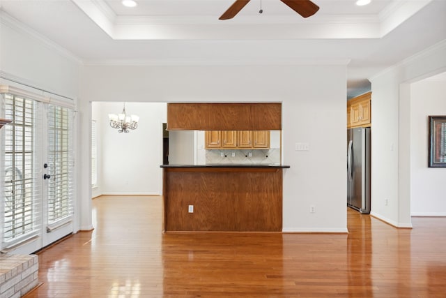 331 Moonshine Hill Rd, Houston, TX 77338 - unfurnished living room featuring light wood-style floors, a tray ceiling, crown molding, and ceiling fan with notable chandelier