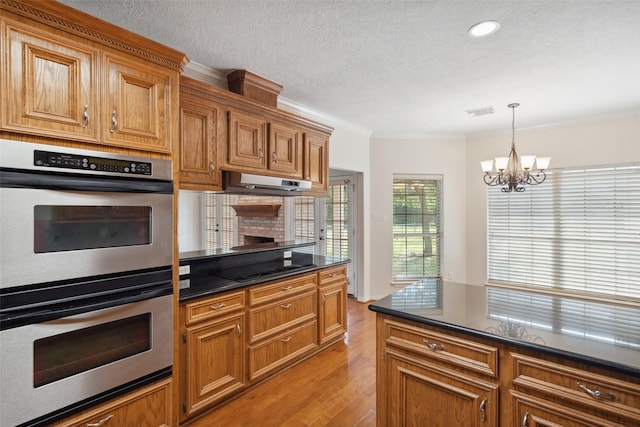331 Moonshine Hill Rd, Houston, TX 77338 - kitchen with brown cabinets, light wood-type flooring, double oven, an inviting chandelier, and crown molding