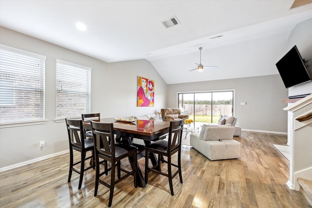 dining space featuring light wood finished floors, visible vents, ceiling fan, and lofted ceiling