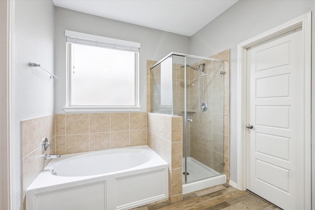 bathroom with wood finished floors, a shower stall, and a bath