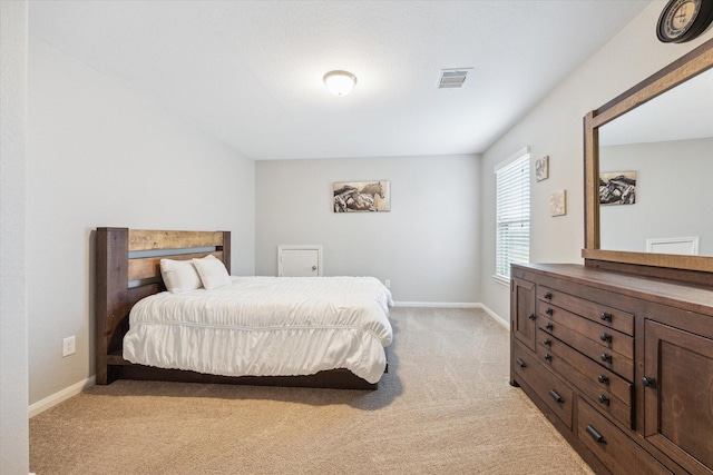 bedroom featuring baseboards, visible vents, and light carpet