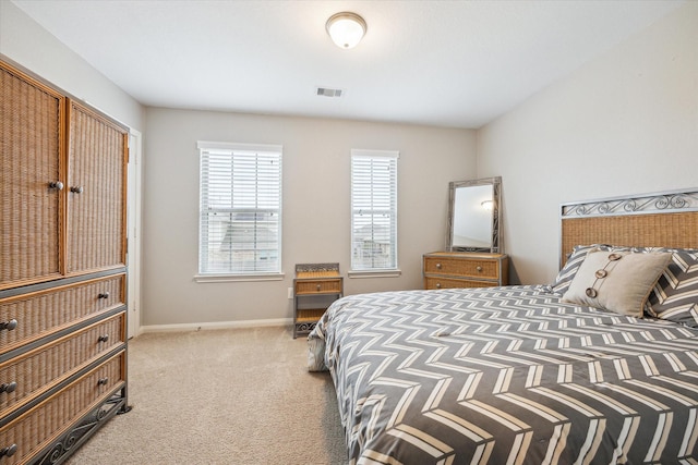 bedroom featuring baseboards, visible vents, and light colored carpet