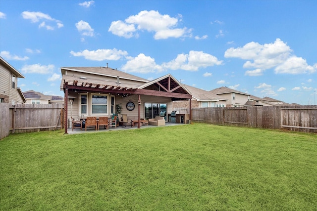 rear view of property with a yard, a patio area, and a fenced backyard