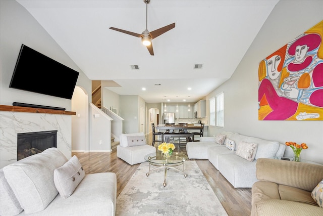 living area with visible vents, ceiling fan, stairway, and light wood-type flooring