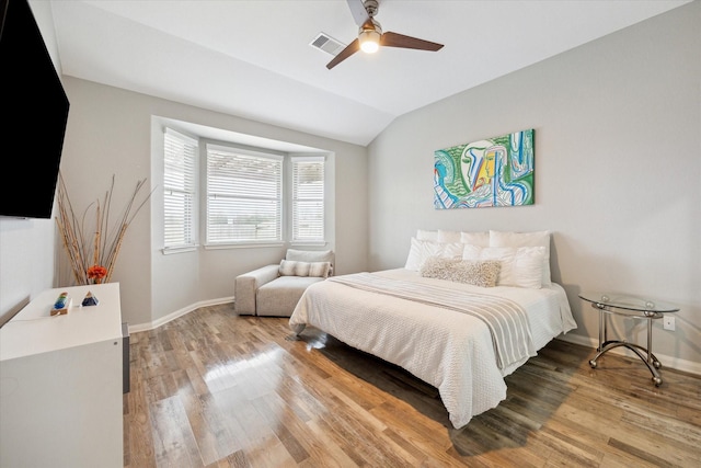 bedroom with lofted ceiling, visible vents, light wood-style flooring, and baseboards