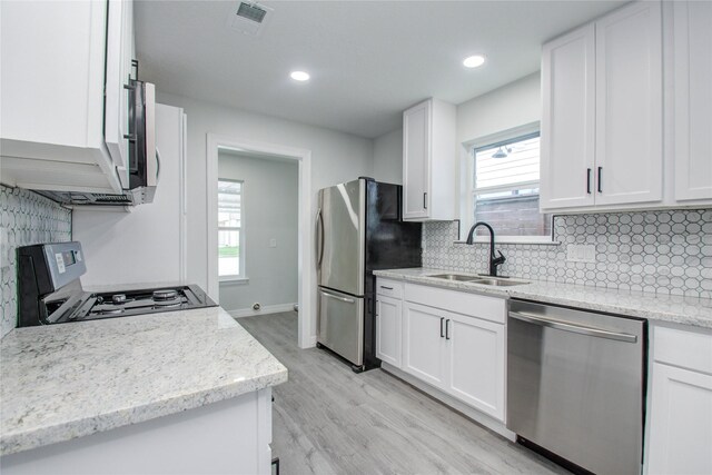 kitchen featuring visible vents, stainless steel appliances, backsplash, and a sink