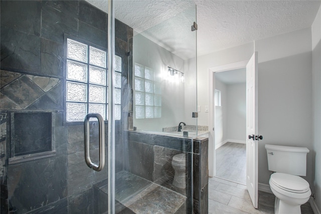 full bath with a textured ceiling, toilet, and a stall shower