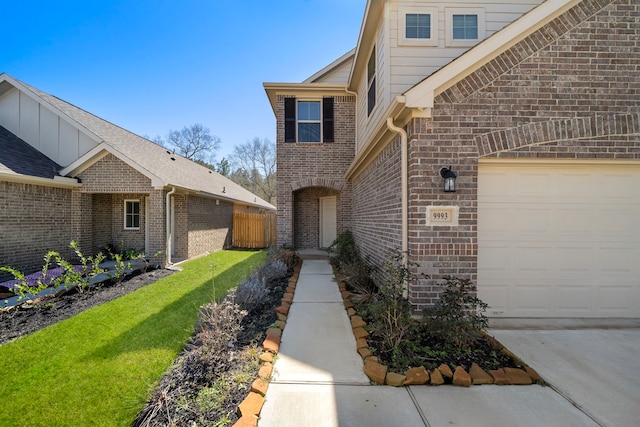 9993 Mountain Lion Ln, Magnolia, TX 77354 - doorway to property with brick siding, fence, board and batten siding, and a lawn