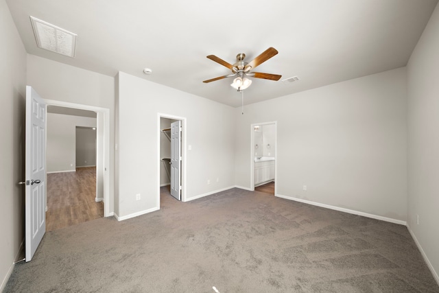 9993 Mountain Lion Ln, Magnolia, TX 77354 - unfurnished bedroom featuring carpet floors, visible vents, baseboards, and a walk in closet