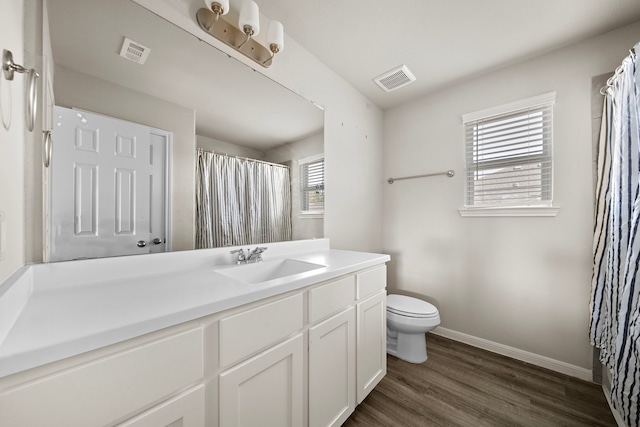 9993 Mountain Lion Ln, Magnolia, TX 77354 - bathroom featuring vanity, toilet, visible vents, baseboards, and wood finished floors