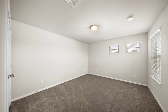9993 Mountain Lion Ln, Magnolia, TX 77354 - unfurnished room with visible vents, dark carpet, and baseboards