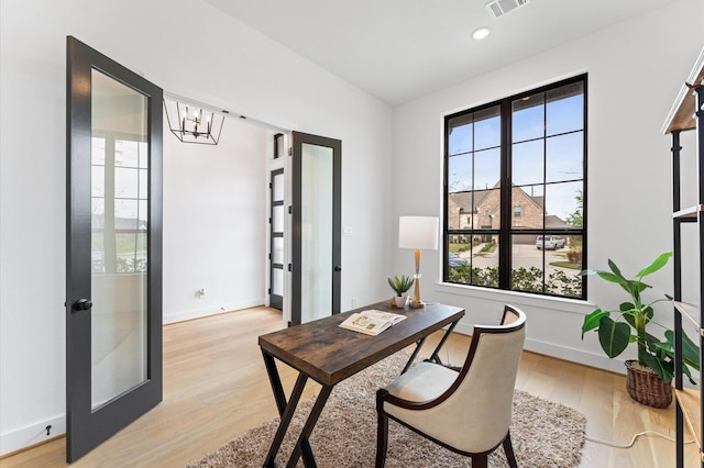 home office with an inviting chandelier, light wood-type flooring, visible vents, baseboards, and french doors