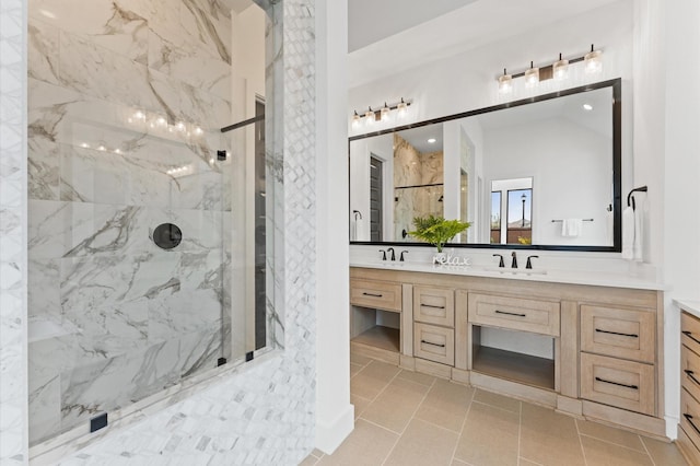 full bath featuring double vanity, a sink, and a marble finish shower