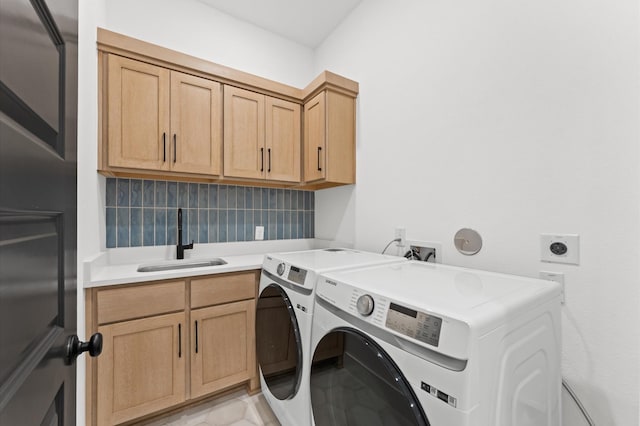 laundry area featuring a sink, cabinet space, and washer and clothes dryer