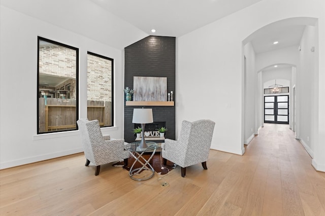 sitting room with wood finished floors, recessed lighting, baseboards, and arched walkways