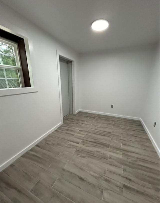 unfurnished room featuring wood finished floors and baseboards