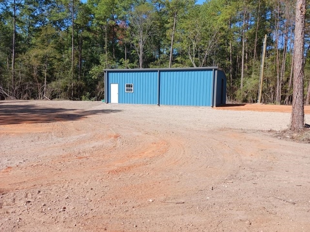 view of outbuilding featuring an outdoor structure and a forest view