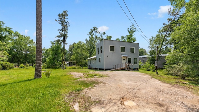 rear view of house featuring dirt driveway