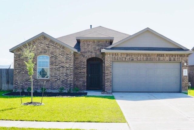 view of front facade featuring brick siding, an attached garage, driveway, and a front yard