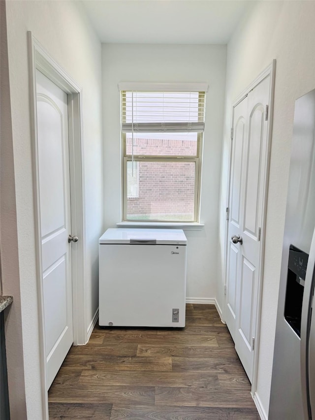 interior space with dark wood-style flooring and baseboards
