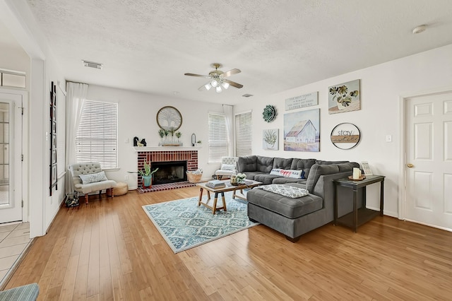 5127 Plantation Colony Dr, Sugar Land, TX 77478 - living area featuring healthy amount of natural light, light wood-style flooring, ceiling fan, a textured ceiling, and a fireplace