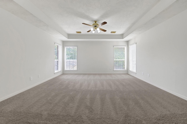 5127 Plantation Colony Dr, Sugar Land, TX 77478 - carpeted spare room featuring a tray ceiling, a ceiling fan, plenty of natural light, baseboards, and a textured ceiling