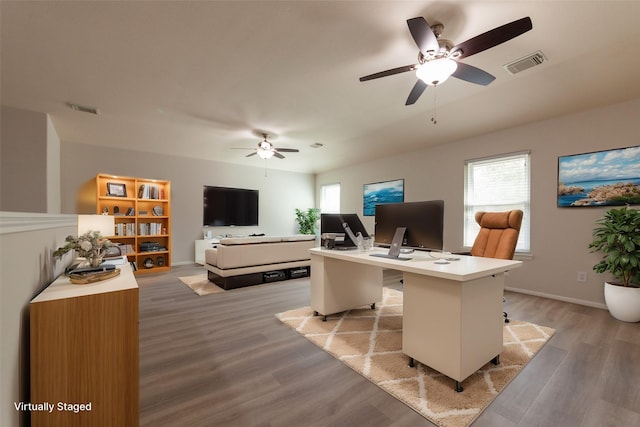 office area featuring baseboards, a ceiling fan, light wood finished floors, and visible vents