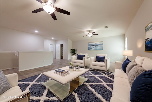 living area with baseboards, a ceiling fan, recessed lighting, and wood finished floors