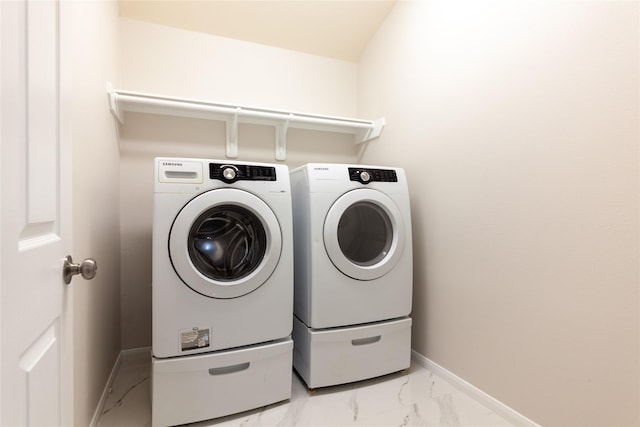 laundry room featuring laundry area, marble finish floor, baseboards, and washer and dryer