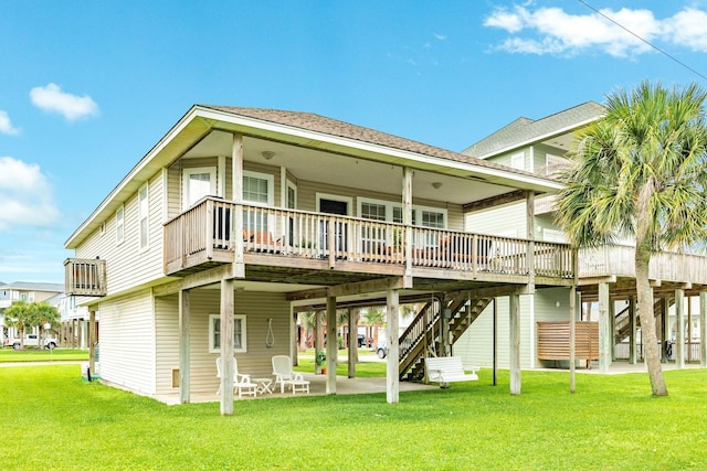 back of property with stairs, a yard, and a patio area