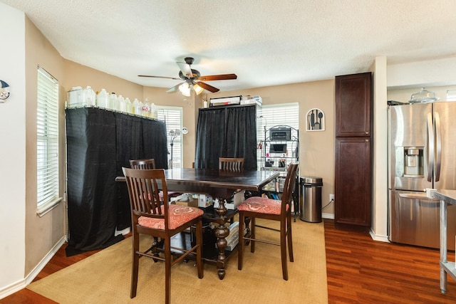 dining room featuring a textured ceiling, ceiling fan, wood finished floors, and baseboards