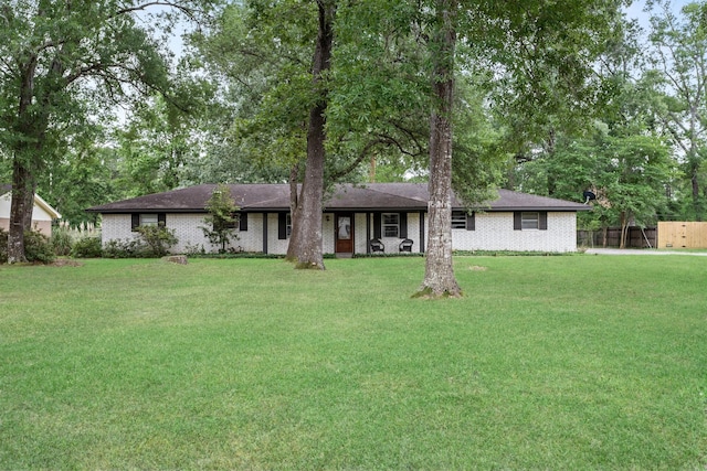 343 Pinemont Dr, Sour Lake, TX 77659 - ranch-style house featuring brick siding, fence, a shingled roof, and a front yard