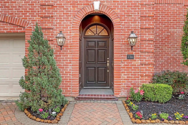 property entrance featuring brick siding and a garage