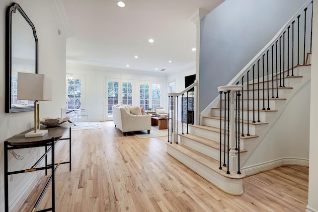 stairs with recessed lighting, ornamental molding, baseboards, and wood finished floors