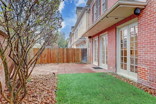 view of yard featuring a patio, fence, and french doors