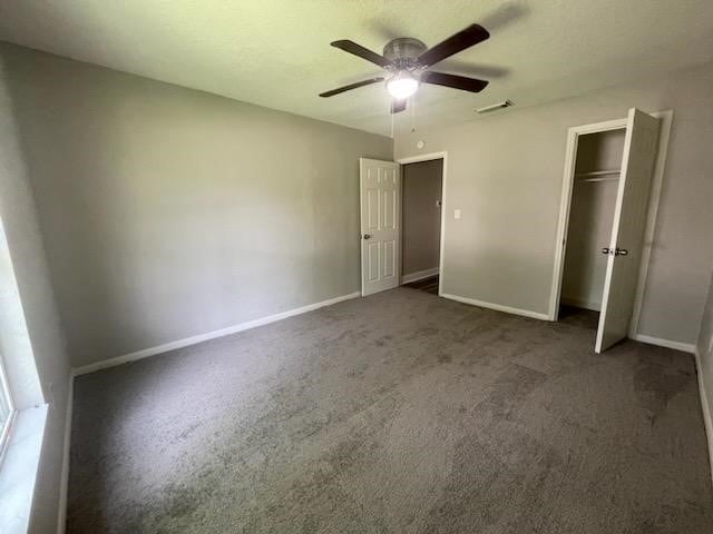 unfurnished bedroom with visible vents, carpet floors, a closet, baseboards, and a ceiling fan