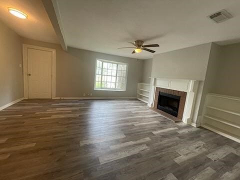 unfurnished living room with visible vents, baseboards, a fireplace, wood finished floors, and a ceiling fan