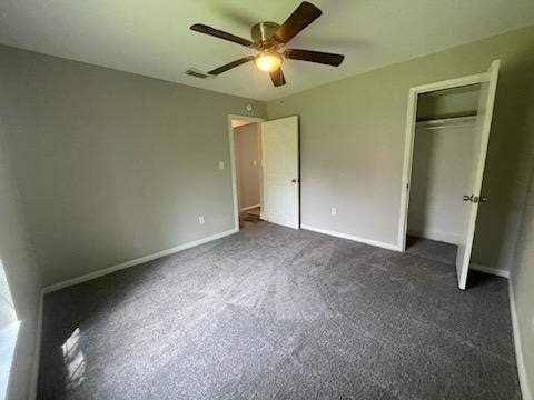 unfurnished bedroom featuring a closet, ceiling fan, visible vents, dark carpet, and baseboards