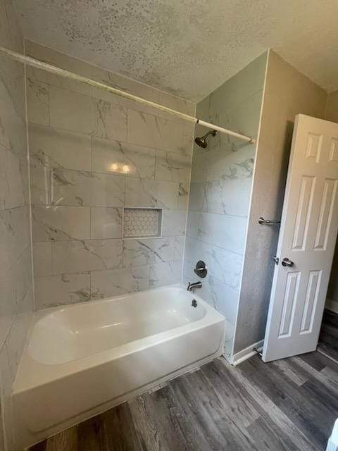bathroom featuring wood finished floors, a textured ceiling, and shower / bath combination