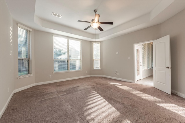 3302 Indigo Acres Ct, Katy, TX 77494 - empty room with visible vents, a wealth of natural light, light colored carpet, and a tray ceiling