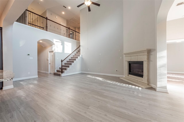 3302 Indigo Acres Ct, Katy, TX 77494 - unfurnished living room with a ceiling fan, stairs, baseboards, a towering ceiling, and arched walkways