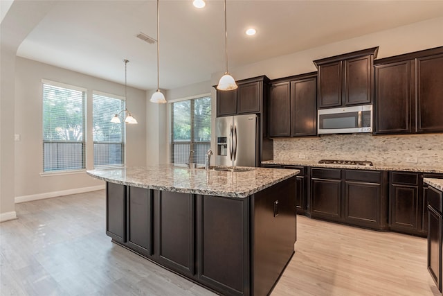 3302 Indigo Acres Ct, Katy, TX 77494 - kitchen with appliances with stainless steel finishes, backsplash, light wood finished floors, and a sink