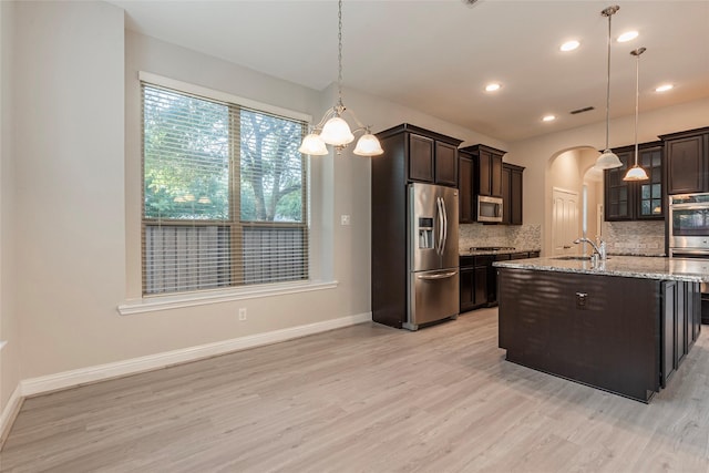 3302 Indigo Acres Ct, Katy, TX 77494 - kitchen with dark brown cabinets, backsplash, appliances with stainless steel finishes, and light wood finished floors