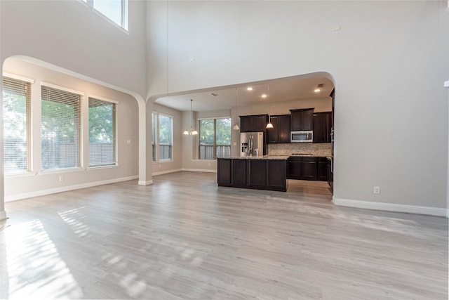 3302 Indigo Acres Ct, Katy, TX 77494 - unfurnished living room with baseboards, arched walkways, and a towering ceiling