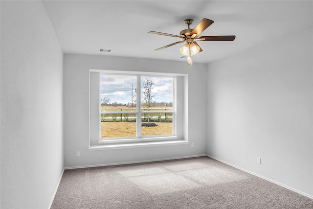 spare room featuring a ceiling fan, carpet flooring, baseboards, and visible vents